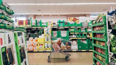 Pasillo de supermercado con un carrito de la compra, sin gente