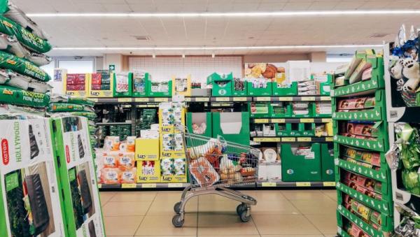 Pasillo de supermercado con un carrito de la compra, sin gente