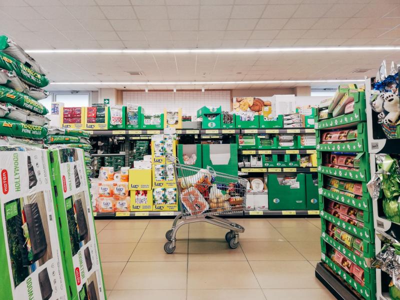 Pasillo de supermercado con un carrito de la compra, sin gente