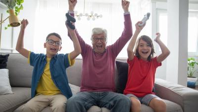 Abuelo jugando a videojuegos con sus nietos