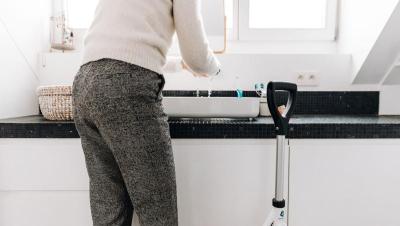 Persona mayor en un cuarto de baño moderno con un andador cerca