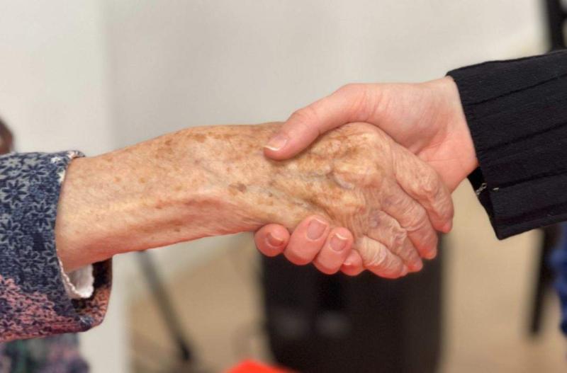 Persona mayor y cuidadora dándose la mano en Centre de Dia Vidactiva, Terrassa