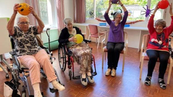 Personas mayores haciendo ejercicio en grupo en un centro de día