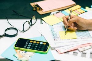 Mesa de escritorio con calculadora, gafas y documentos para la declaración de la renta