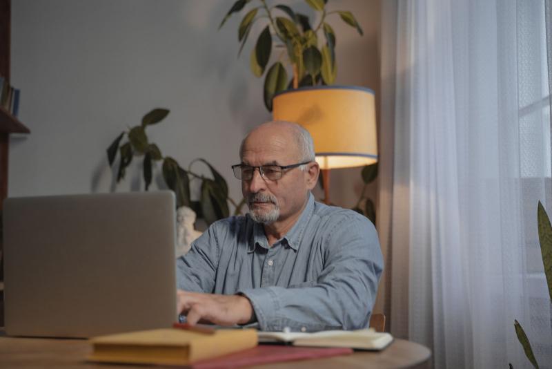 Hombre mayor haciendo un trámite online en su portátil