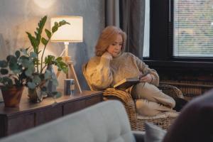 Mujer mayor leyendo tranquilamente en un sillón acogedor