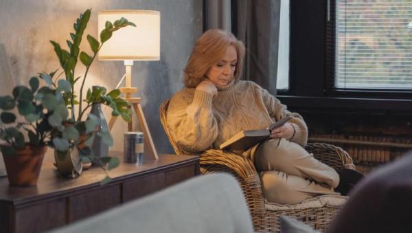 Mujer mayor leyendo tranquilamente en un sillón acogedor