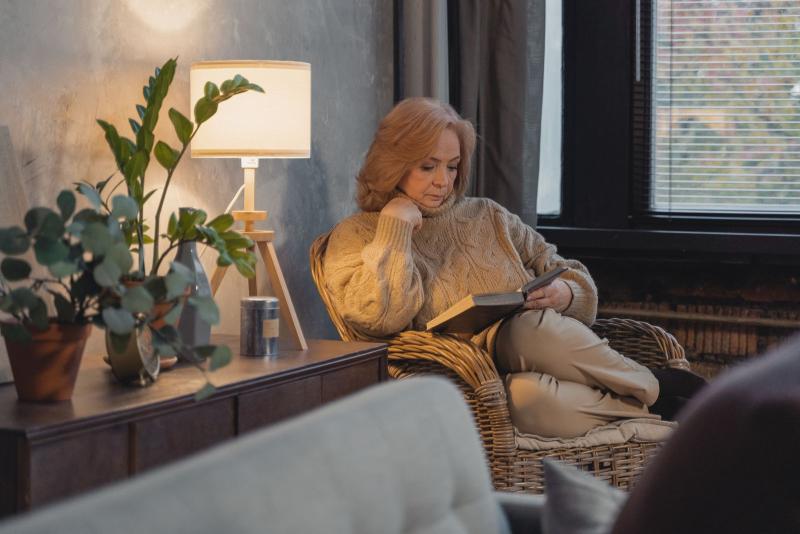 Mujer mayor leyendo tranquilamente en un sillón acogedor