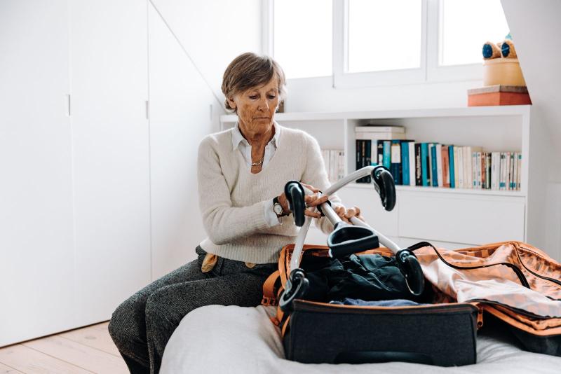 Mujer mayor preparando la maleta para viajar sola