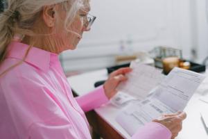 Mujer mayor revisando papeleo en casa