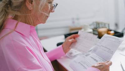Mujer mayor revisando papeleo en casa