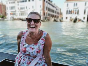 Mujer mayor sonriendo en Venecia con los canales de fondo