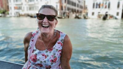 Mujer mayor sonriendo en Venecia con los canales de fondo