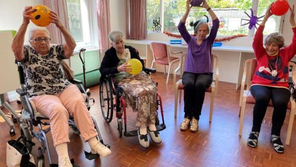 Mujeres mayores haciendo ejercicio con pelotas en un centro comunitario