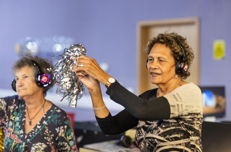 Dos mujeres mayores con auriculares disfrutando de una sesión de musicoterapia