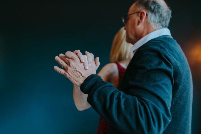 Pareja mayor bailando agarrados de la mano