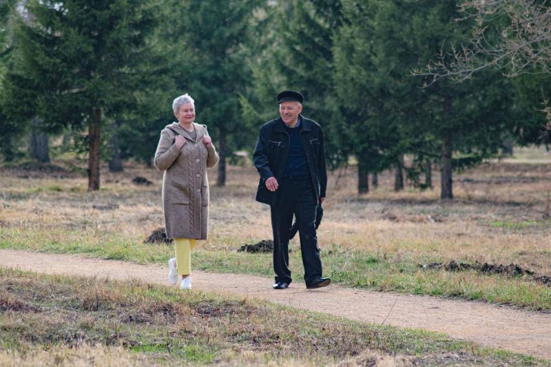 Pareja mayor caminando y charlando por un parque