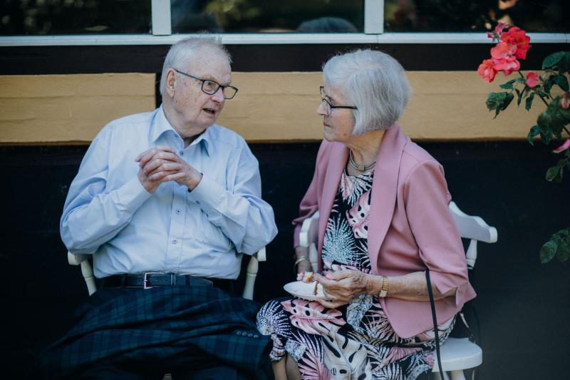 Pareja de personas mayores charlando tranquilamente en un jardín