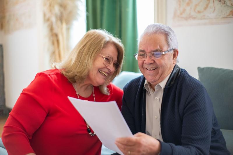 Pareja mayor leyendo juntos un documento en casa