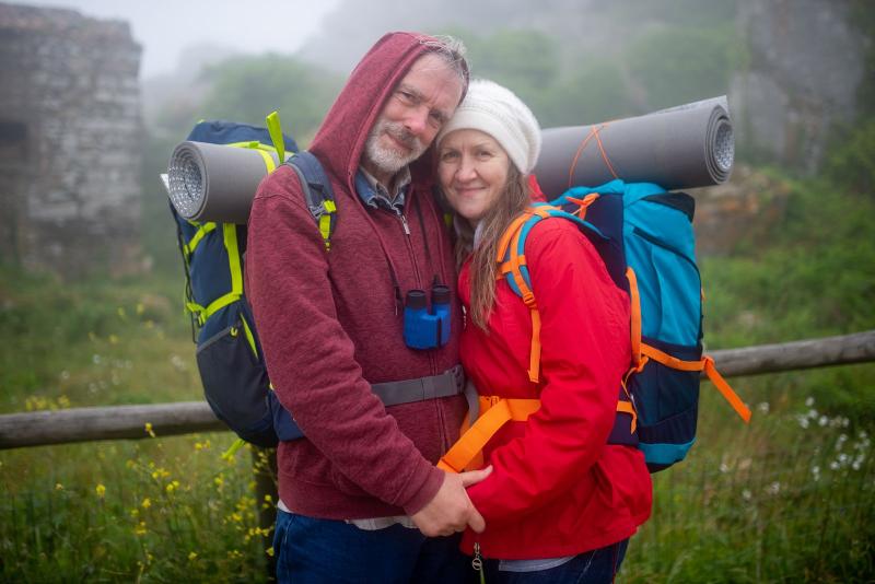 Pareja mayor con mochilas de senderismo en una escapada rural