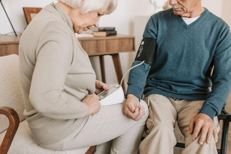 Pareja de personas mayores midiéndose la tensión arterial en casa