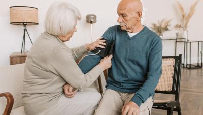 Pareja mayor midiéndose la tensión arterial juntos en casa