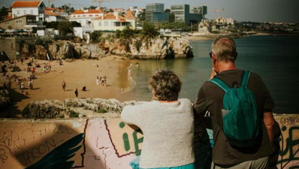 Pareja mayor disfrutando de las vistas de la playa de Cascais en Portugal